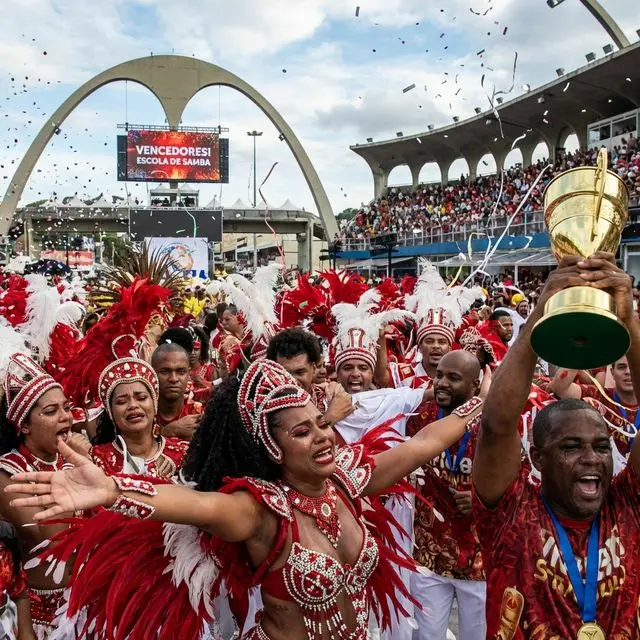 Celebração da vitória com integrantes da escola de samba comemorando o título no Sambódromo